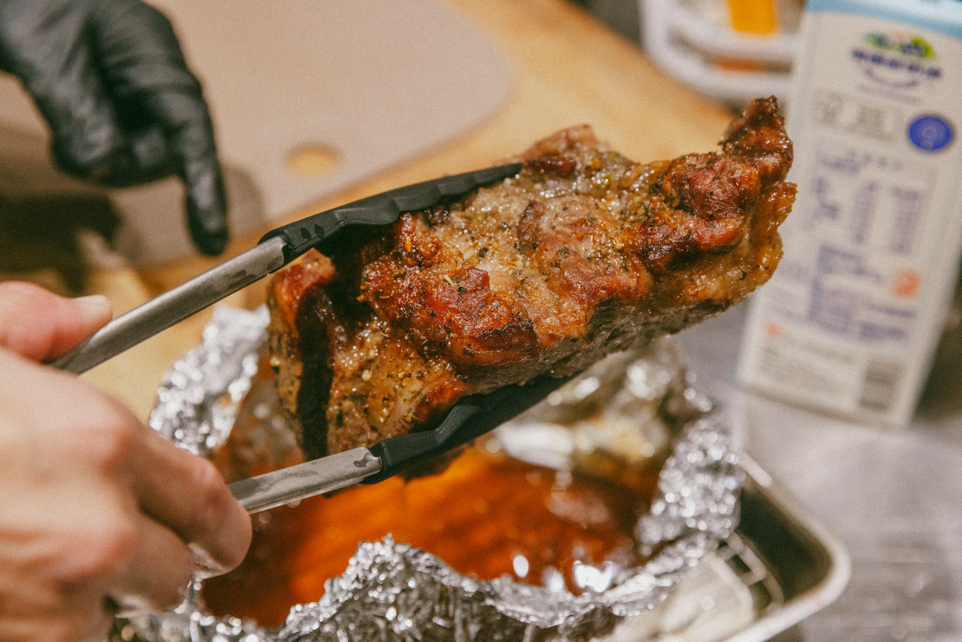 Hands working with meat and foil